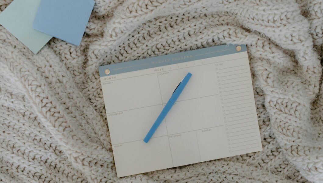 top view of a weekly planner on a knitted blanket