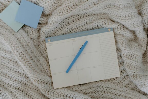 top view of a weekly planner on a knitted blanket